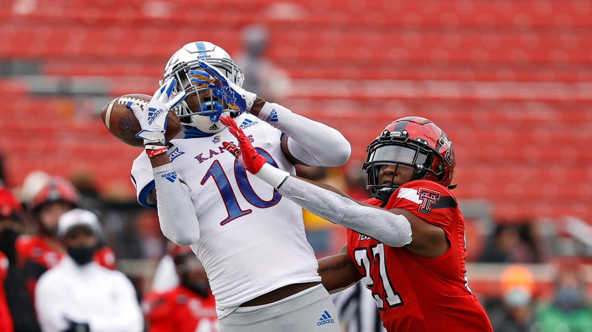 Texas Tech’s Alex Hogan (27) breaks up a pass intended for Kansas’ Tristan Golightly (10) during the first half of a college football game Saturday, Dec. 5, 2020, in Lubbock, Texas.