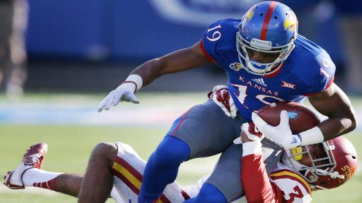 
Kansas wide receiver Justin McCay (19) was tackled by Iowa State defensive back Nigel Tribune (34) in the first half Saturday in Lawrence
