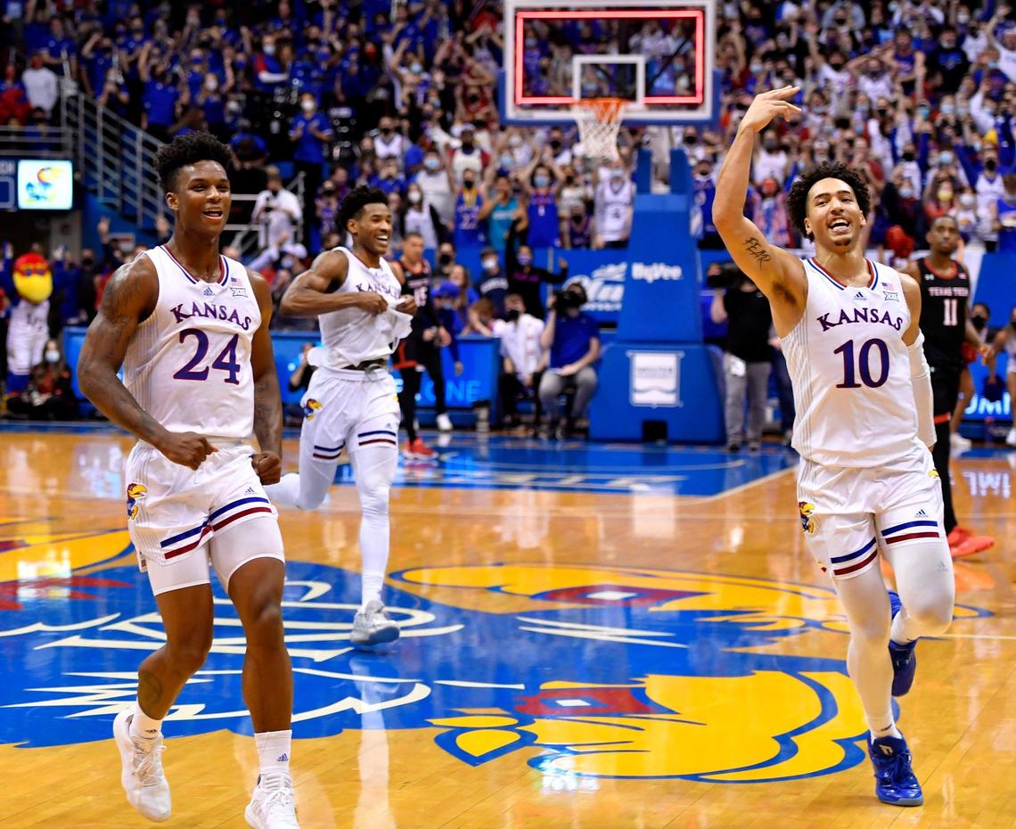 After surviving a 94-91 double overtime thriller over Texas Tech, KU’s KJ Adams, left, Ochai Agbaji and Jalen Willson head toward the KU bench to celebrate Monday night at Allen Fieldhouse.