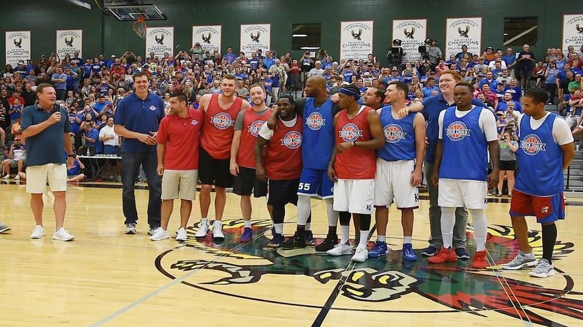 Kansas basketball coach Bill Self (left) addressed the crowd at Lawrence Free State High School while some members of the 2008 national championship team stood at halfcourt during the Rock Chalk Roundball Classic on Thursday night.