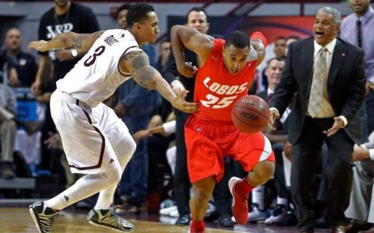 
New Mexico guard Tim Jacobs (25) was fouled by New Mexico State forward Remi Barry as New Mexico State head coach Marvin Menzies (right) reacted on Dec. 20 in Las Cruces, N.M. New Mexico won 69-67.
