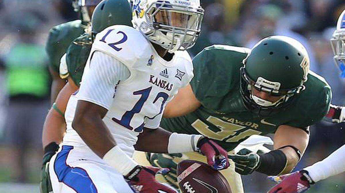 
Kansas wide receiver Darious Crawley (12) lost the ball as he was hit by Baylor’s Nacita Silas (31) in the first half Saturday in Waco, Texas. 
