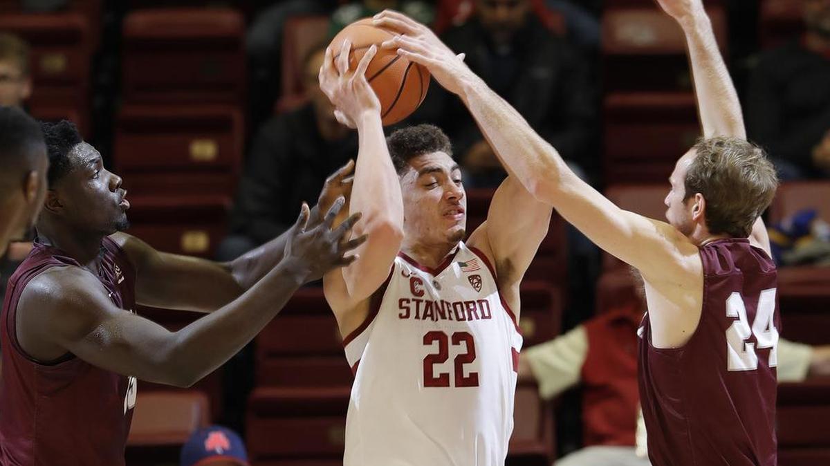 Stanford forward Reid Travis (22) is defended by Montana forward Jamar Akoh, left, and guard Bobby Moorehead during the first half of an NCAA college basketball game Wednesday, Nov. 29, 2017, in Stanford, Calif.
