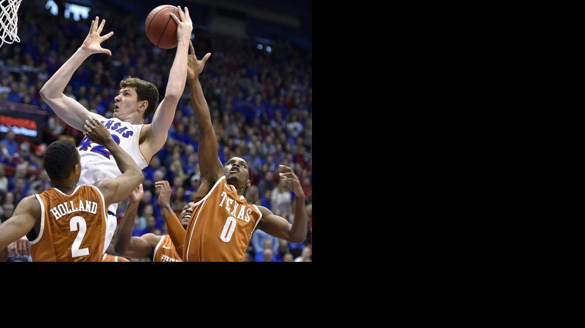 
Kansas reserve center Hunter Mickelson grabbed a rebound over Texas' Demarcus Holland (left) and Kendal Yancy during the first half of Saturday's game at Allen Fieldhouse.


