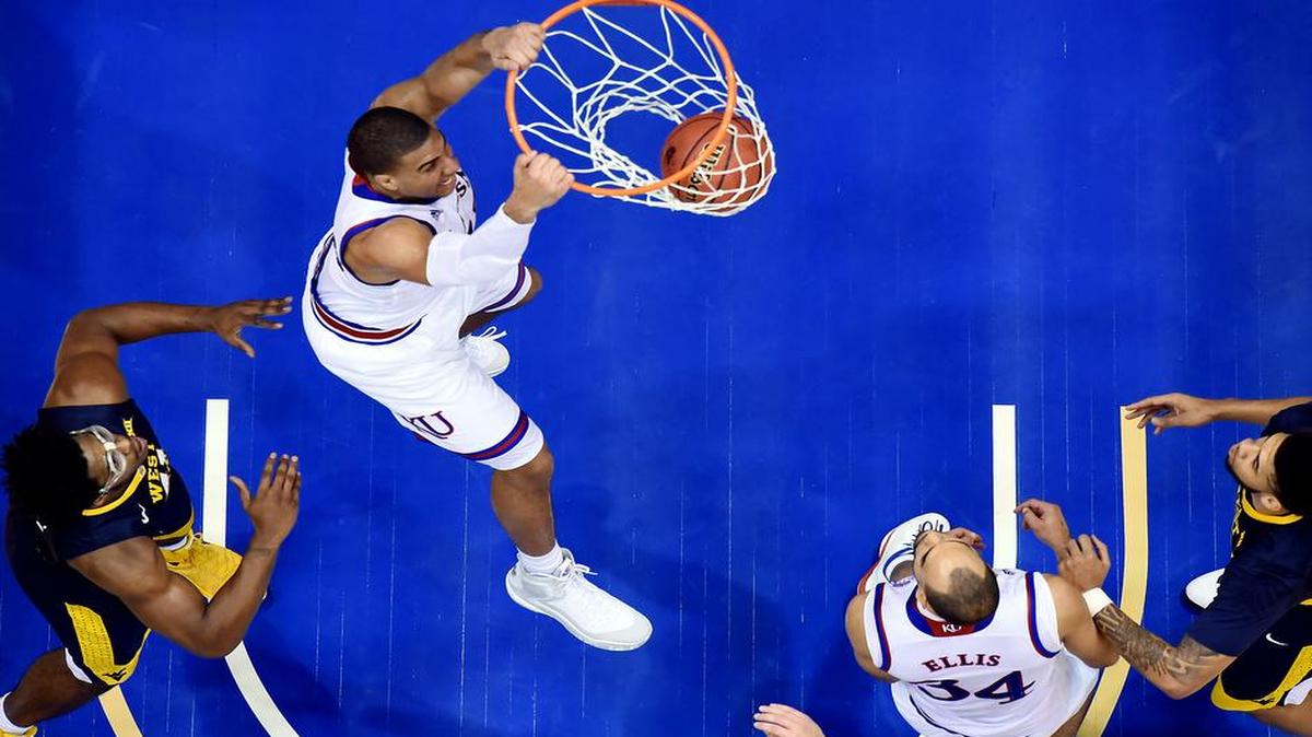 KU's Landen Lucas came up huge for the Jayhawks Tuesday night. He got by West Viginia's Devin Williams (left) and put down a thunderous dunk during the second half of Tuesday night's game at Allen Fieldhouse. Lucas finished with nine points, four blocks and a game-high 16 rebounds. KU won, 75-65.