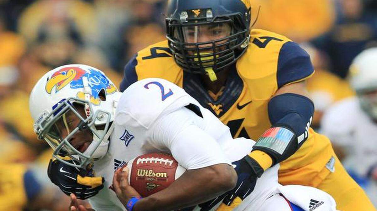 
West Virginia’s Shaquille Riddick (4) tackled Kansas quarterback Montell Cozart in the first quarter on Saturday in Morgantown, W.Va.
