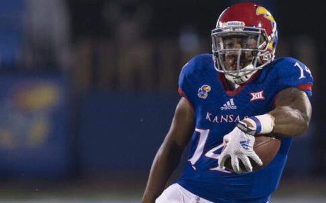 
Kansas Jayhawks quarterback Michael Cummings tried to keep his feet as Southeast Missouri State Redhawks nose tackle Marlon Hampton grabbed an ankle in the fourth quarter on September 6, 2014, in Lawrence.
