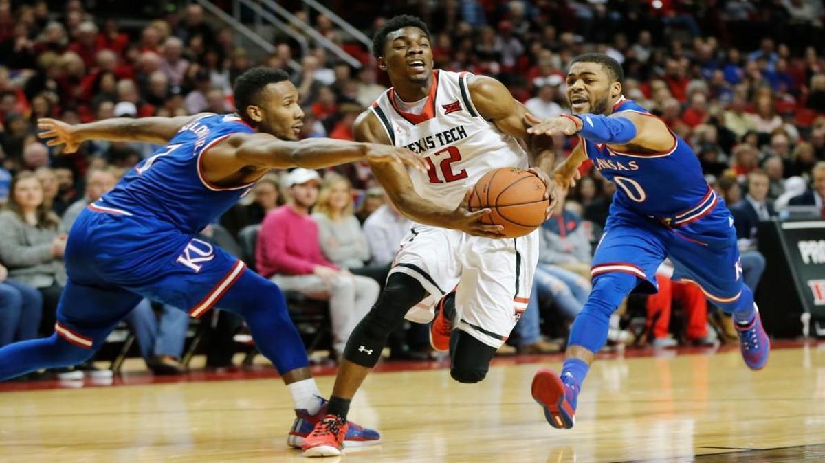 Texas Tech guard Keenan Evans (center) drove to the basket defended by Kansas guard Wayne Selden (left) and Frank Mason in the first half Saturday in Lubbock, Texas.
