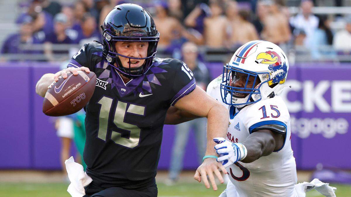 TCU quarterback Max Duggan (left) tries to scramble away from Kansas defensive end Kyron Johnson during last year’s meeting in Fort Worth, Texas.