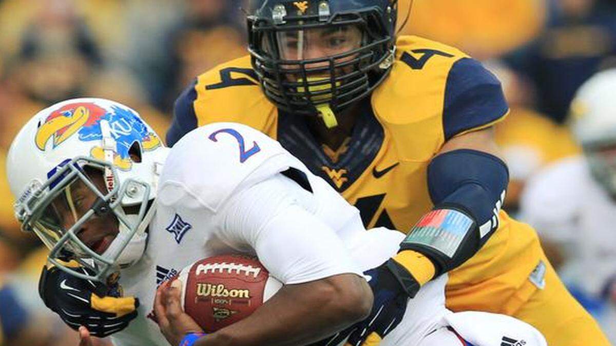 
West Virginia’s Shaquille Riddick (4) tackled Kansas quarterback Montell Cozart in the first quarter Saturday in Morgantown, W.Va.
