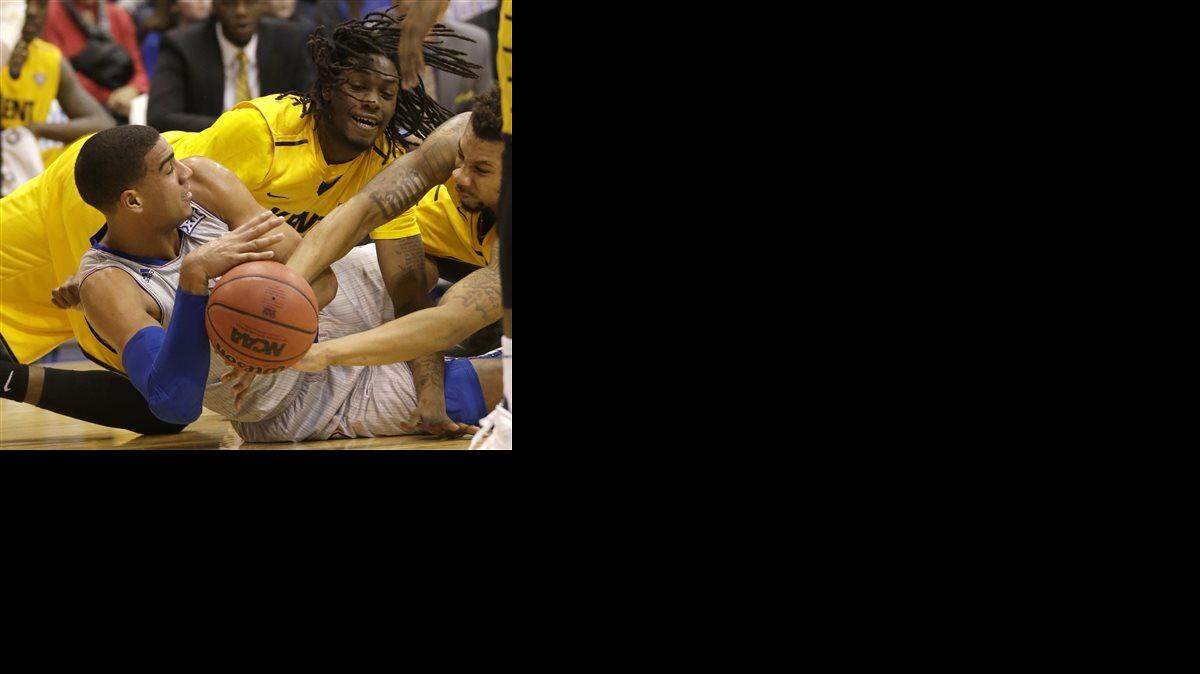 Kansas forward Landen Lucas (33) hits the floor with Kent State forward Marquiez Lawrence, back, and guard Devareaux Manley, right, during the first half of an NCAA college basketball game in Lawrence, Kan., Tuesday, Dec. 30, 2014.