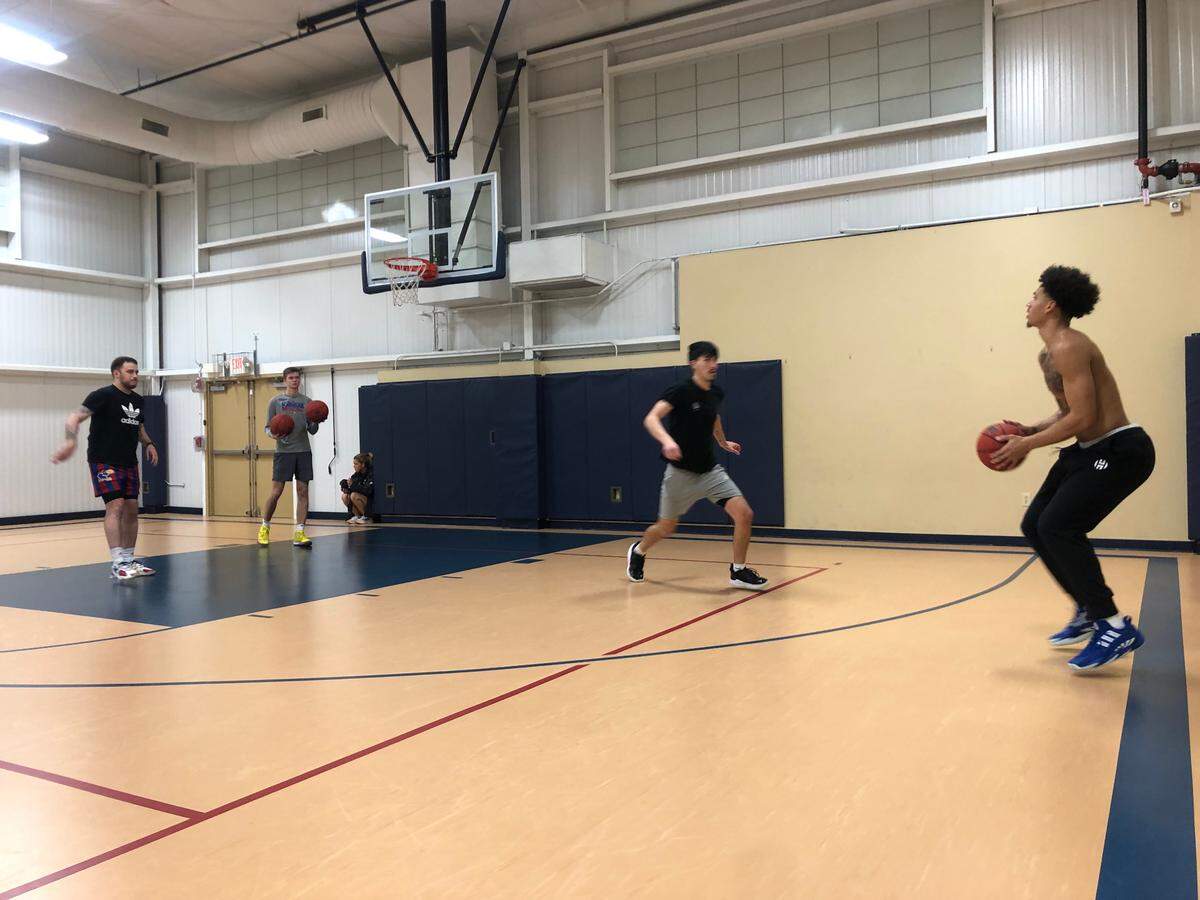 Kansas basketball junior Jalen Wilson, right, puts up a workout shot with 90/10 Training’s Peter Danyliv, left, passing and head assistant trainer Keifer Puyear, center, defending. Wilson’s workout took place Feb. 21, 2022, at Immanuel Lutheran Church in Lawrence, Kansas.