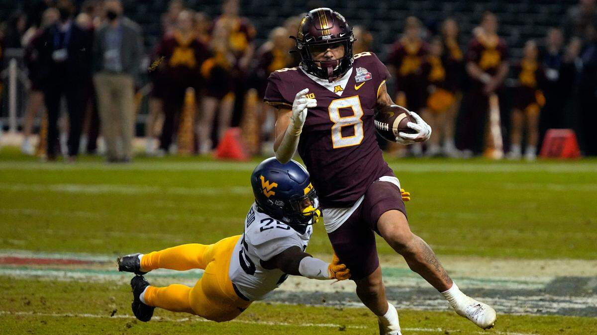 Minnesota running back Ky Thomas (8) gets away form West Virginia safety Saint McLeod during the second half of the Guaranteed Rate Bowl on Tuesday, Dec. 28, 2021, in Phoenix. Minnesota won, 18-6.