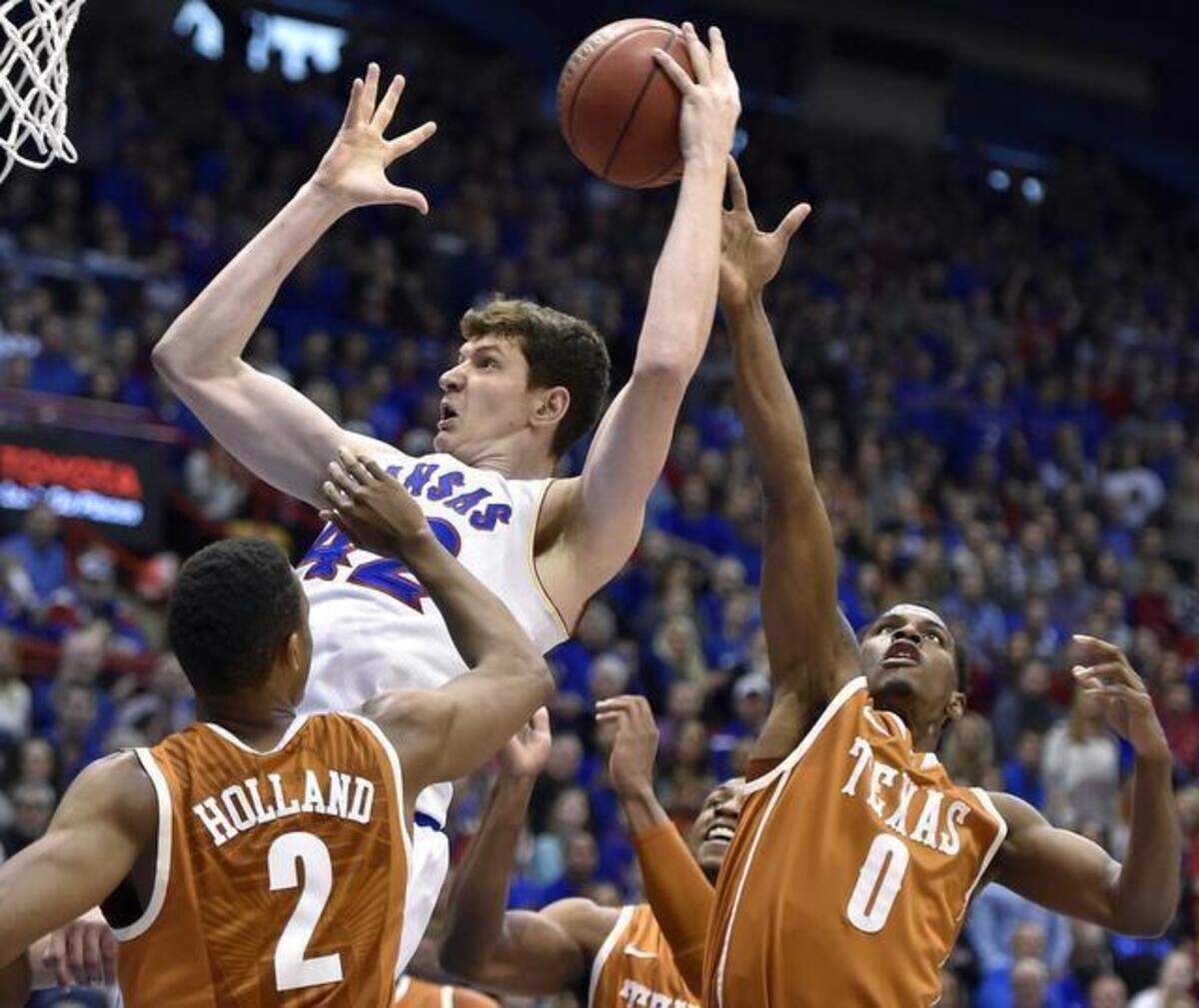 
Kansas’ Hunter Mickelson grabbed an offensive rebound over Texas’ Demarcus Holland (2) and Kendal Yancy in the first half of the Jayhawks’ 69-64 come-from-behind win over the Longhorns on Saturday at Allen Fieldhouse in Lawrence. The No. 9 Jayhawks play their last home game of the season when they face the No. 20 West Virginia Mountaineers at 8 p.m. tonight.
