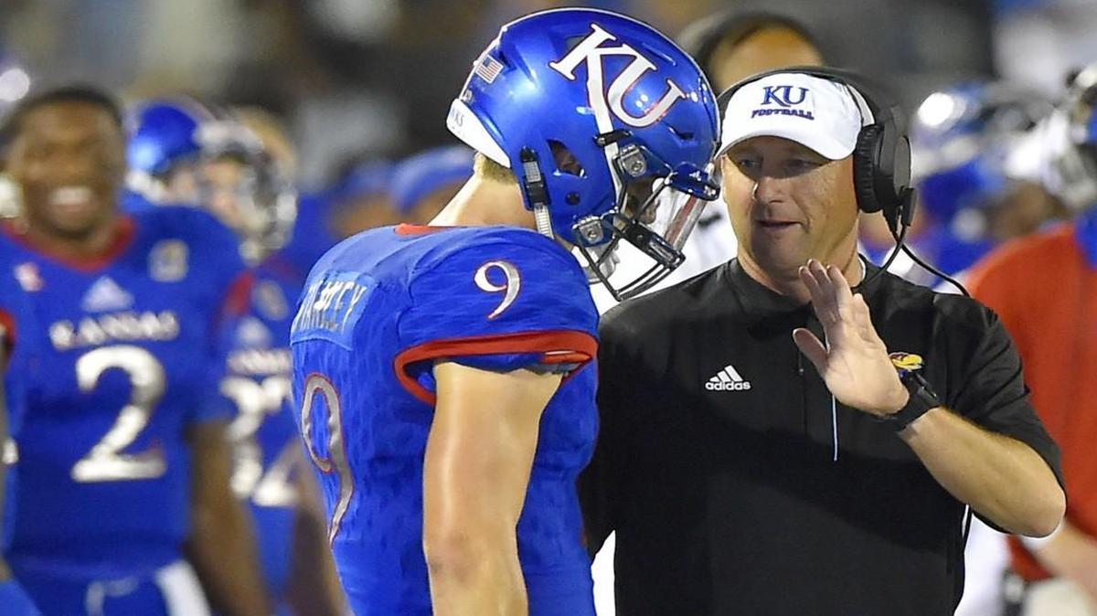 Kansas head coach David Beaty talked to quarterback Carter Stanley (9) after Stanley had thrown a touchdown pass on Sept. 3 during the fourth quarter against the Rhode Island.