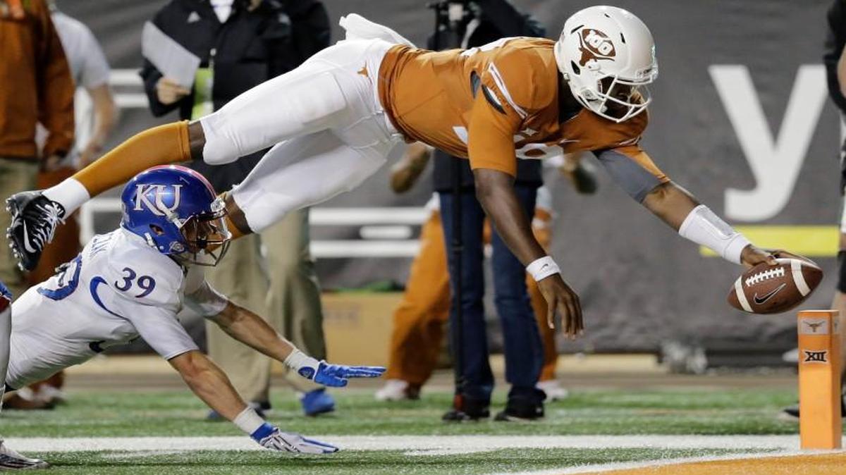 Texas quarterback Tyrone Swoopes (18) dove for a touchdown as Kansas defenders Tyrone Miller Jr. (19) and Michael Glatczak chased him in the second half of the Longhorns’ 59-20 win on Saturday night in Austin, Texas.