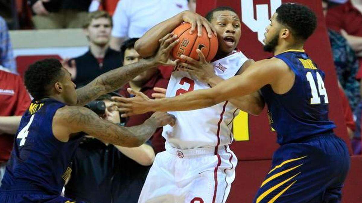 
Oklahoma guard Dinjiyl Walker (center) worked to keep the ball away from West Virginia guard Daxter Miles Jr. (left) and guard Gary Browne in Oklahoma’s 71-52 win on Feb. 3 in Norman, Okla. West Virginia has been one of the top defensive teams in the country this season.


