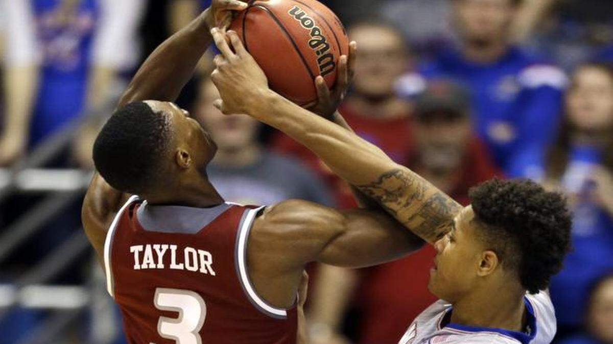 
Kansas guard Kelly Oubre Jr. (right) blocked a shot by Rider guard Jimmie Taylor during the first half Monday.
