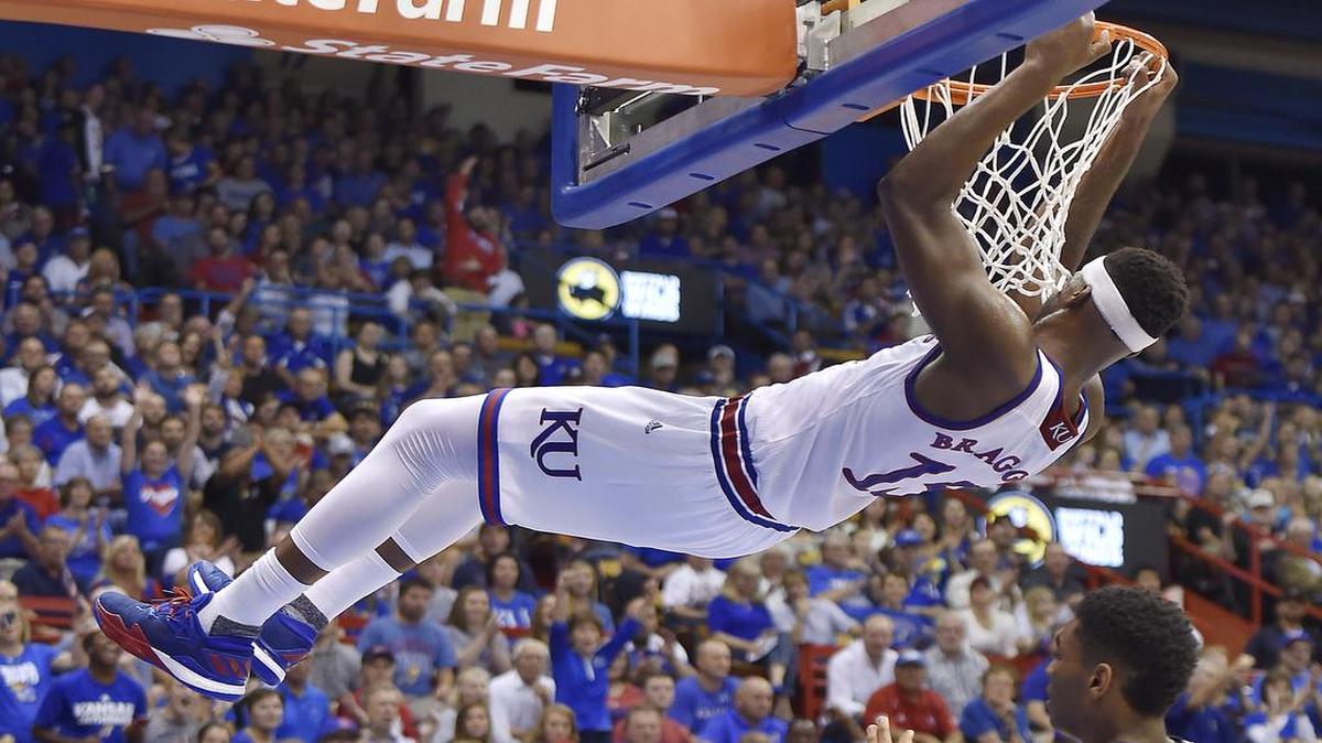 KU's Carlton Bragg hangs on the rim after dunking over Washburn's Emeka obonna during the first half of Tuesday night's exhibition game at Allen Fieldhouse.