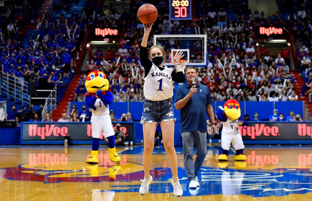 Libby Frost, a sophomore WaKeeney, Kansas, takes the winning three-point shot that earned her $5,000 from KU coach Bill Self, rear, during Late Night in the Phog Friday night at Allen Fieldhouse.