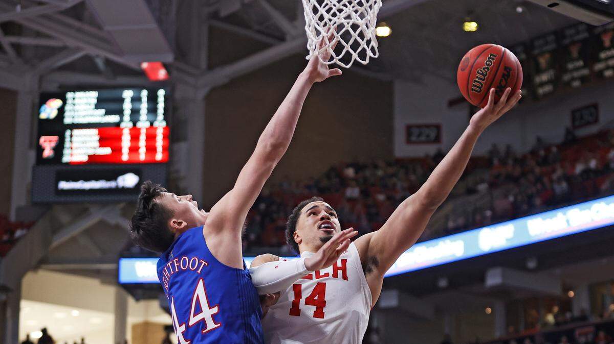 Texas Tech’s Marcus Santos-Silva (right) lays up the ball around Kansas’ Mitch Lightfoot during the second half of a game on Saturday, Jan. 8, 2022, in Lubbock, Texas.
