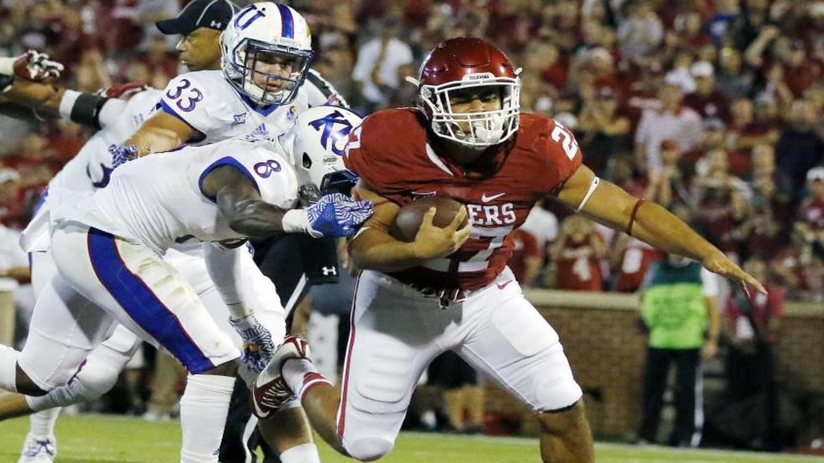 Oklahoma running back Devin Montgomery scored a touchdown ahead of Kansas cornerback Brandon Stewart during Saturday’s game.