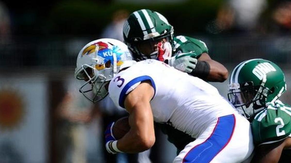 KU’s Chase Harrell tried to escape from the grasp of an Ohio defender in Saturday’s game in Athens, Ohio.