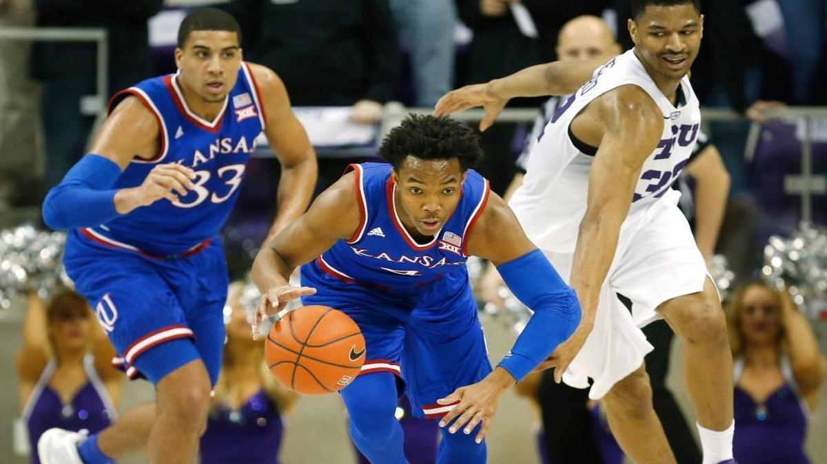 Kansas guard Devonte' Graham (center) steals the ball from TCU forward Karviar Shepherd (right) as Kansas forward Landen Lucas (33) joins the break during Saturday’s Big 12 game in Fort Worth.