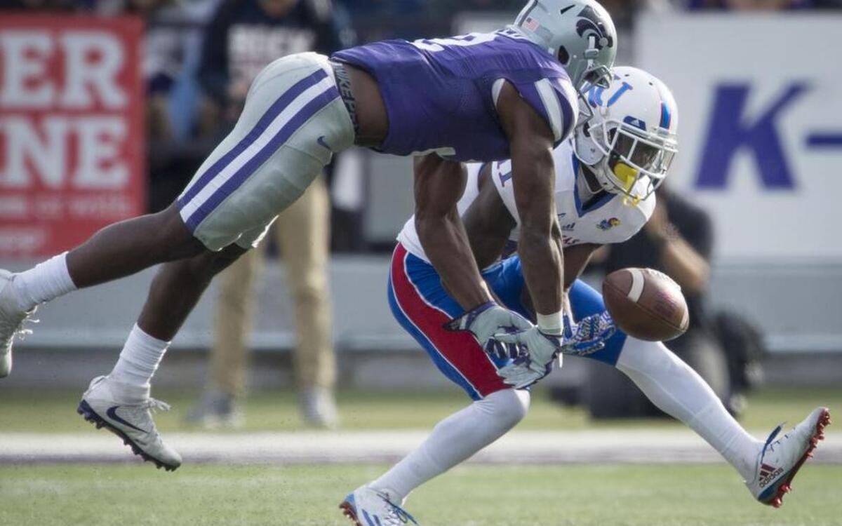 Kansas State’s D.J. Reed (left) lunged to break up a pass intended for KU’s Steven Sims in the fourth quarter of Saturday’s game in Manhattan, Kan.