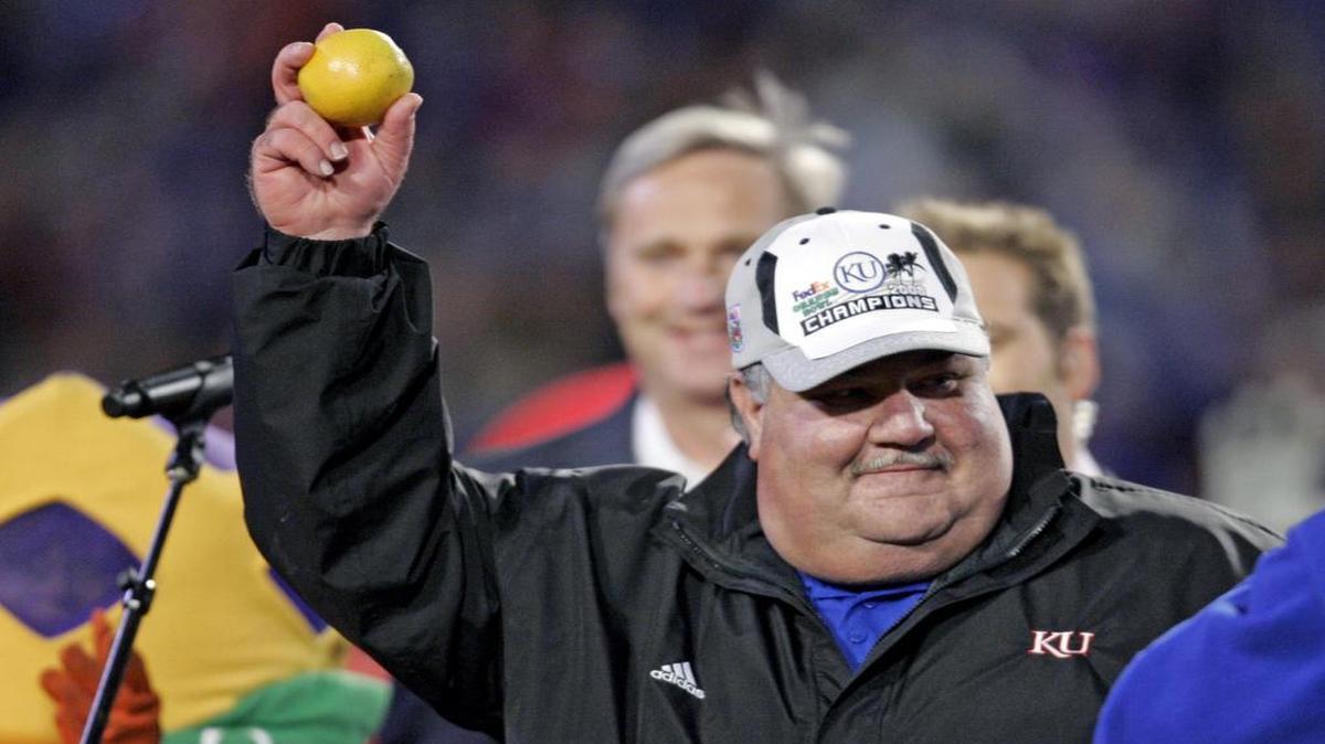 In this Jan. 3, 2008, file photo, Kansas head football coach Mark Mangino holds an orange after their 24-21 win over Virginia Tech in the Orange Bowl.