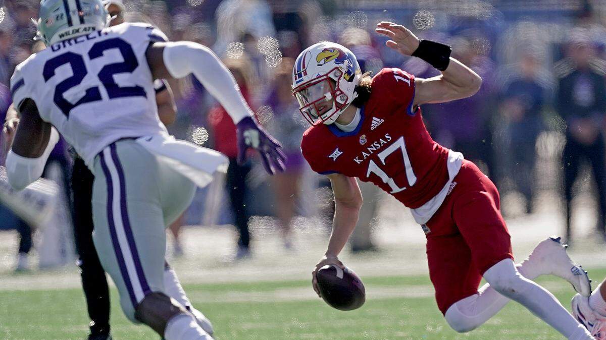 Kansas quarterback Jason Bean (17) gets past Kansas State linebacker Daniel Green (22) during the first half of a game against Kansas Saturday, Nov. 6, 2021, in Lawrence, Kan.