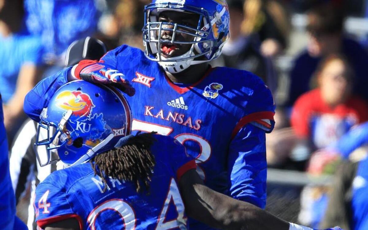 KU running back Taylor Martin (front, No. 24) was congratulated by teammate Hakeem Adeniji after scoring a touchdown during the first half of Saturday’s game against Iowa State in Lawrence.