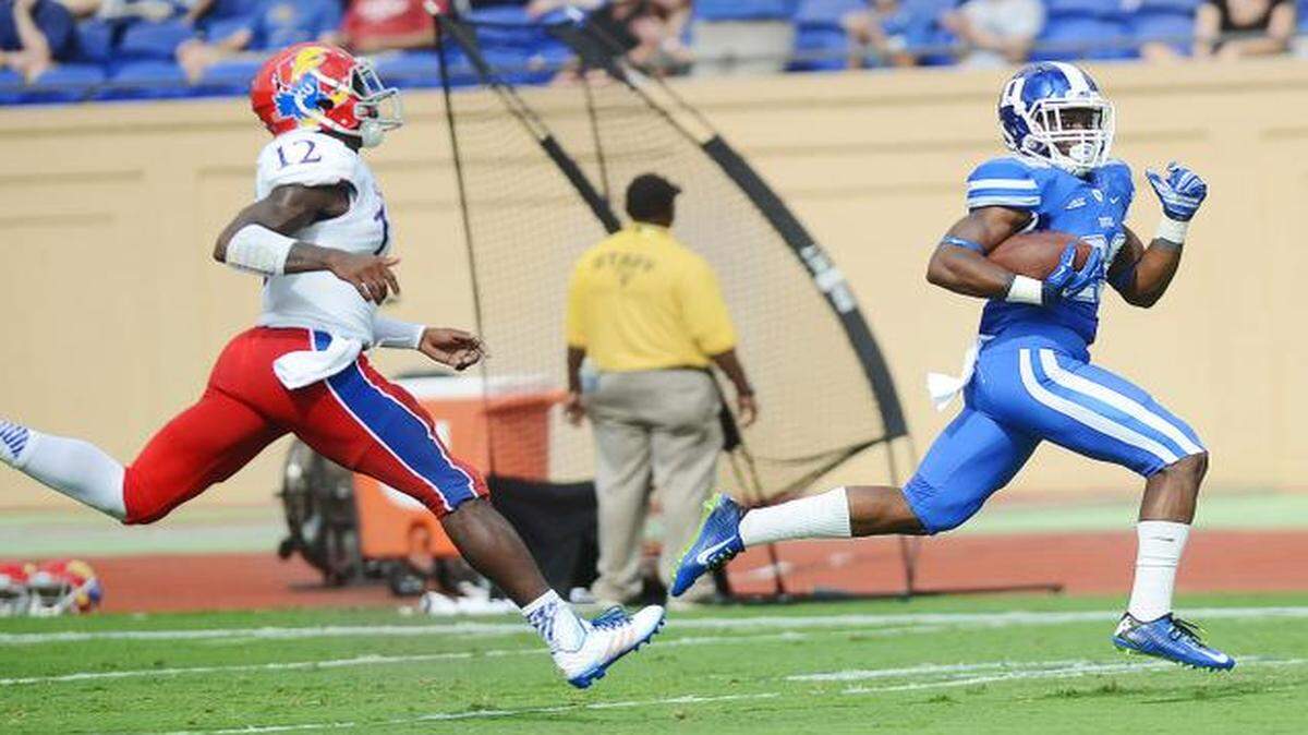 
Duke’s Shaun Wilson (right) scored a touchdown against Kansas’ Darious Crawley during the first half Saturday in Durham, N.C. 
