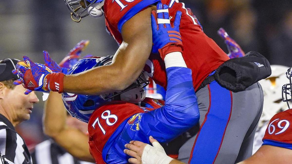 Kansas offensive lineman Hakeem Adeniji (78) picked up running back Khalil Herbert after Herbert scored a touchdown during the second half against Texas last season at Memorial Stadium in Lawrence. The Jayhawks defeated the Longhorns 24-21 in overtime.