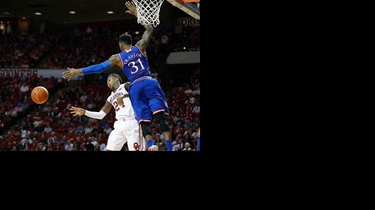 
Oklahoma guard Buddy Hield (24) passes off in front of Kansas forward Jamari Traylor (31) in the second half of an NCAA college basketball game in Norman, Okla., Saturday, March 7, 2015. Oklahoma won 75-73. 
