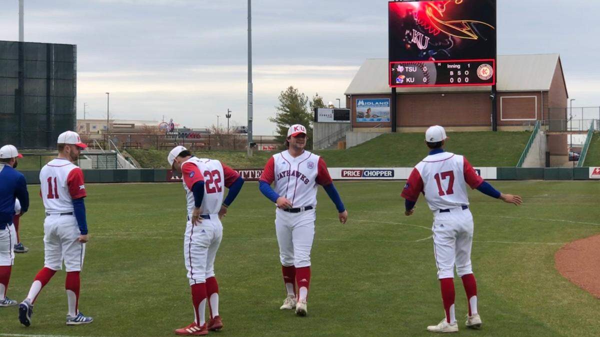 Kansas Jayhawks first baseman Cooper McMurray, second from right, runs during warmups as sophomore Tavian Josenberger from Kansas City, Missouri (22) tucks in his uniform ahead of the Buck O’Neil Classic at Legends Field on Tuesday in Kansas City, Kansas. Josenberger was wearing No. 22 in honor of Buck O’Neil, who will be inducted into the Baseball Hall of Fame this summer. KU wore Kansas City Monarchs replica jerseys on Tuesday night, while Texas Southern wore ones representing the Homestead Grays.