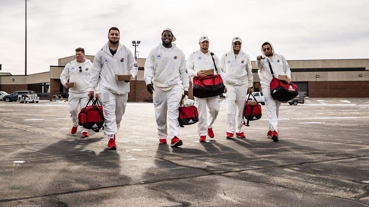 Kansas football players walk to the plane ahead of a trip to Memphis for the 2022 Liberty Bowl. Kansas arrived in Memphis on Sunday and will face Arkansas on Wednesday, Dec. 28.