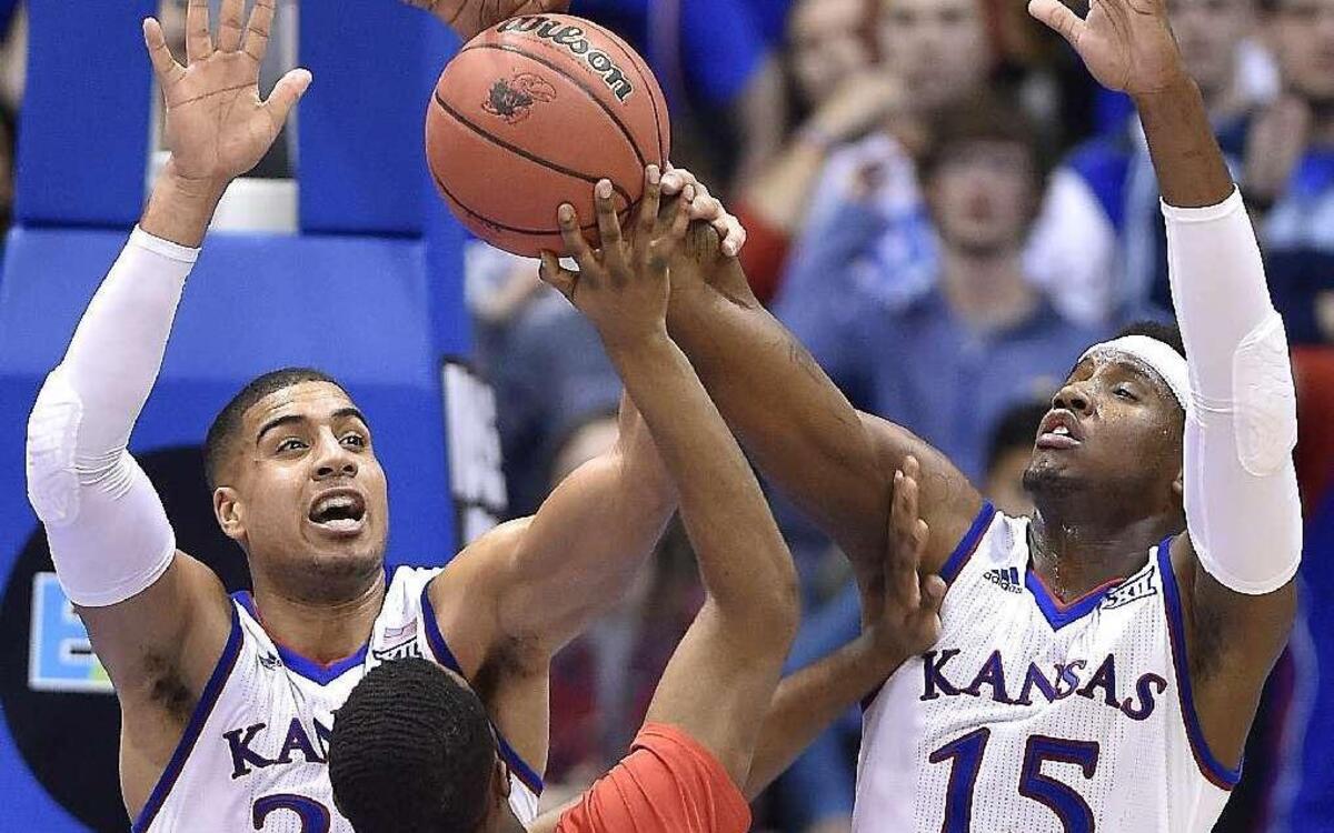 KU’s Landen Lucas (left) and Carlton Bragg smothered a shot attempt by Texas Tech’s Niem Stevenson during the second half of Saturday night’s game at Allen Fieldhouse. KU beat Texas Tech, 85-68.