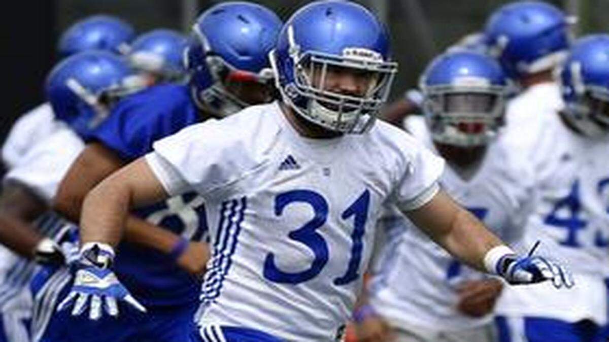 
KU’s football team gets ready for the season on the practice field near Memorial Stadium Friday, Aug. 8, 2014. Linebacker Ben Heeney (31) and teammates do drills.
