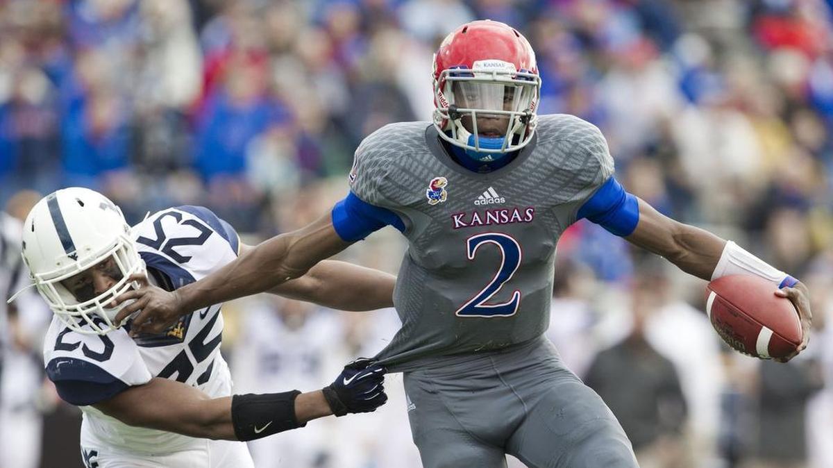 
Kansas quarterback Montell Cozart shook off a tackle by West Virginia’s Darwin Cook of West Virginia during the first half. The Kansas Jayhawks defeated the West Virginia Mountaineers, 31-19, at Memorial Stadium in Lawrence.
