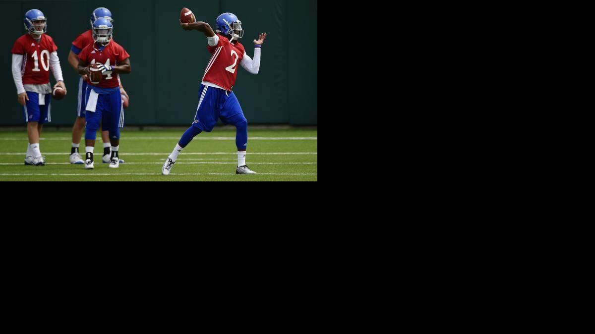 
KU’s football team got ready for the season Friday on the practice field near Memorial Stadium. As fellow quarterbacks wait their turn, starter Montell Cozart (right) threw passes during drills.

