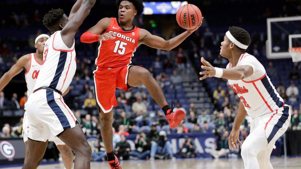 Georgia guard Sahvir Wheeler (15) drives between Mississippi defenders Khadim Sy (3) and Devontae Shuler (2) in the first half of an NCAA college basketball game in the Southeastern Conference Tournament in Nashville, Tenn.