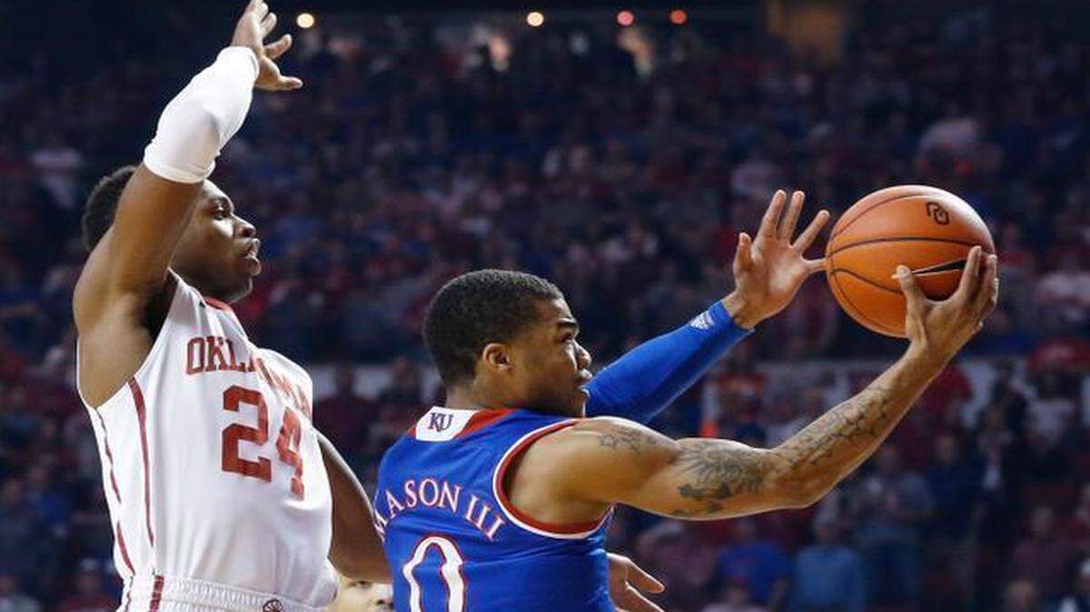 
Kansas guard Frank Mason took a shot against Oklahoma guard Buddy Hield during Saturday’s game in Norman, Okla.
