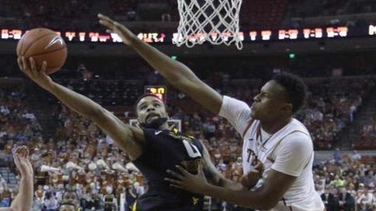 
Texas’ Myles Turner (right) defended the basket against West Virginia’s Jaysean Paige.
