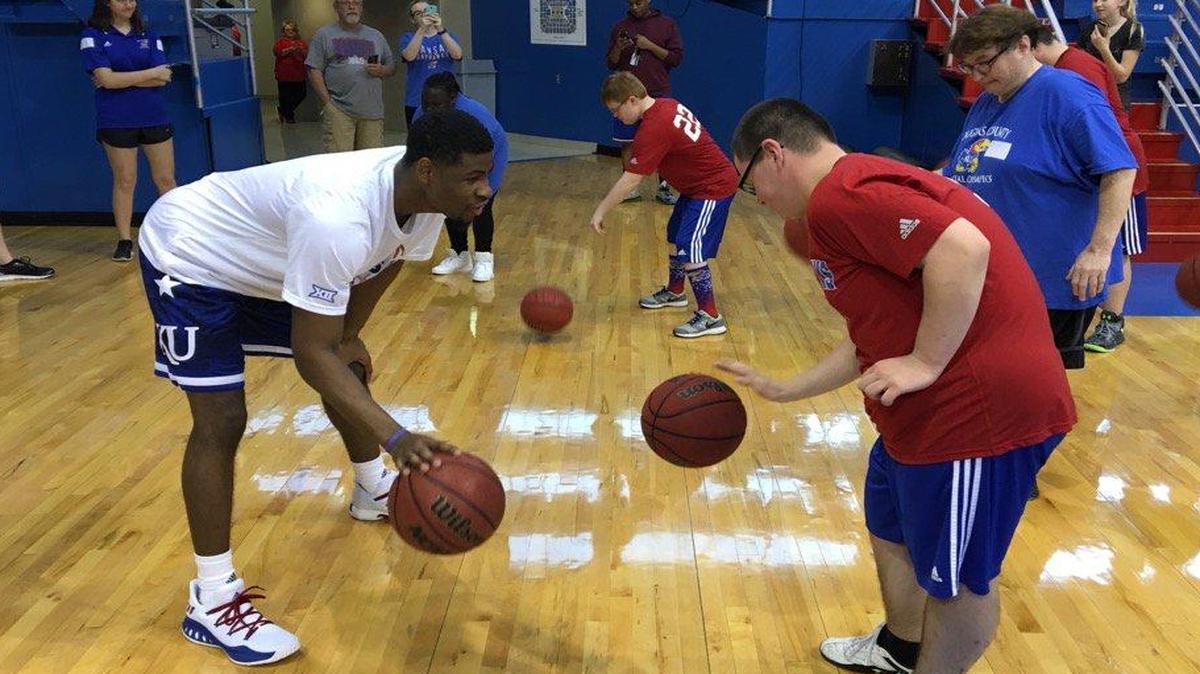 KU sophomore Malik Newman instructed a camper in the art of dribbling at the Special Olympics clinic Sunday at Allen Fieldhouse.