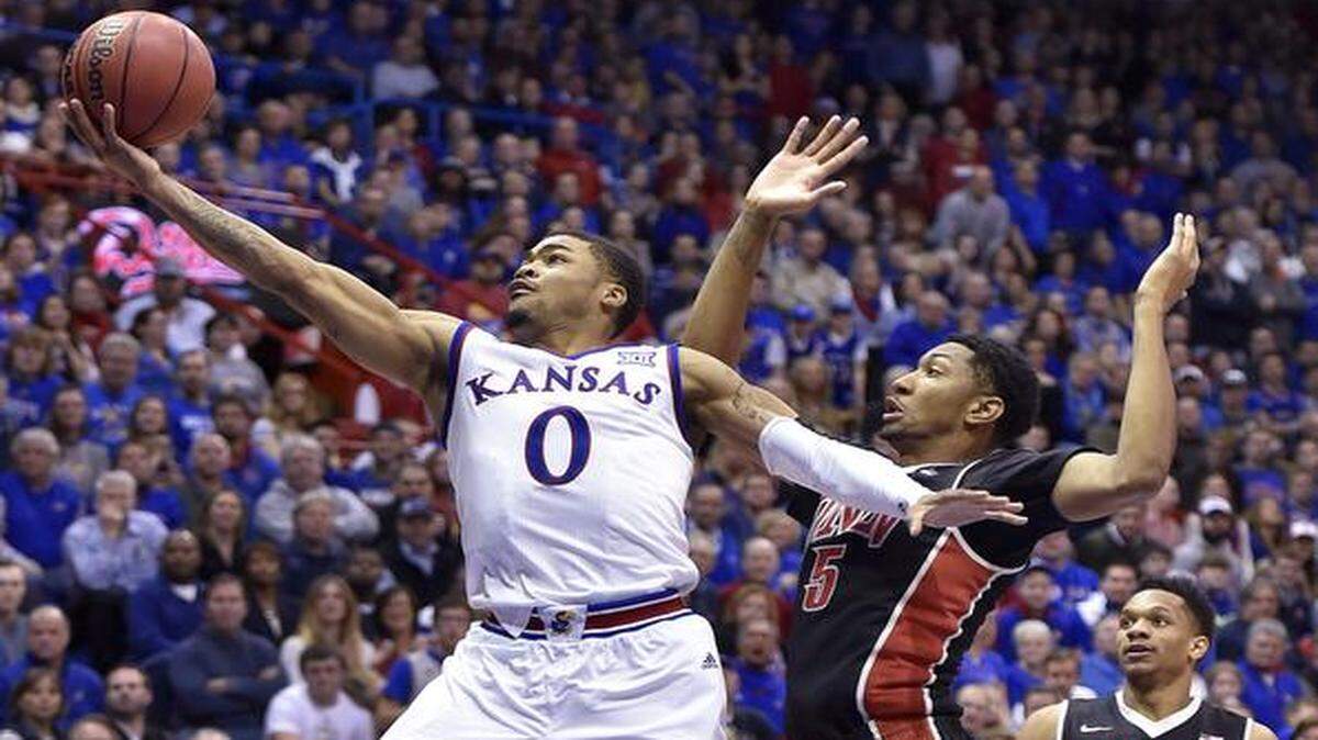 KU's Frank Mason, who led all scorers with 18 points, drove hard by UNLV's Christian Wood for a bucket during the second half of Sunday's game at Allen Fieldhouse. KU pulled away late in the game to take a 76-61 win.