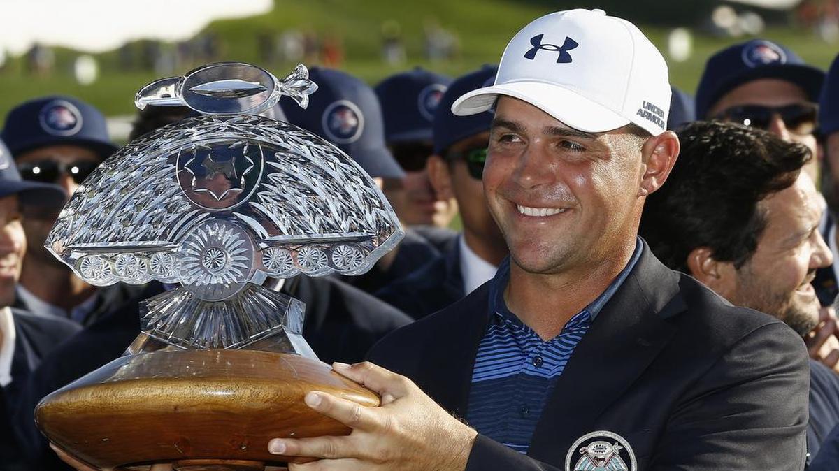 Former KU golfer Gary Woodland smiled as he held the trophy he won by beating Chez Reavie in a playoff Saturday at the Waste Management Phoenix Open in Scottsdale, Ariz.