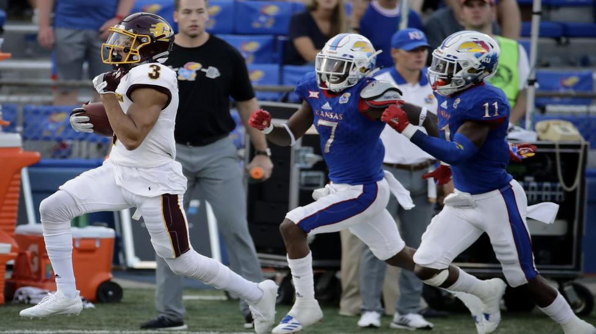 Central Michigan wide receiver Mark Chapman was chased by Kansas cornerback Derrick Neal and safety Mike Lee (right) as Chapman ran the ball 75 yards for a touchdown during the second half on Saturday in Lawrence.