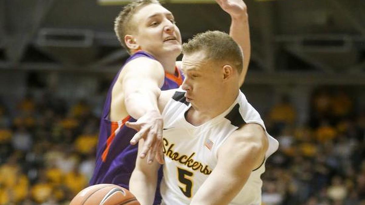 Wichita State guard Zach Bush (5) dishes the ball against Evansville center Sergej Vucetic for one of his two assists Tuesday night at Koch Arena. The No. 25 Shockers cruised past the Purple Aces 109-83.
