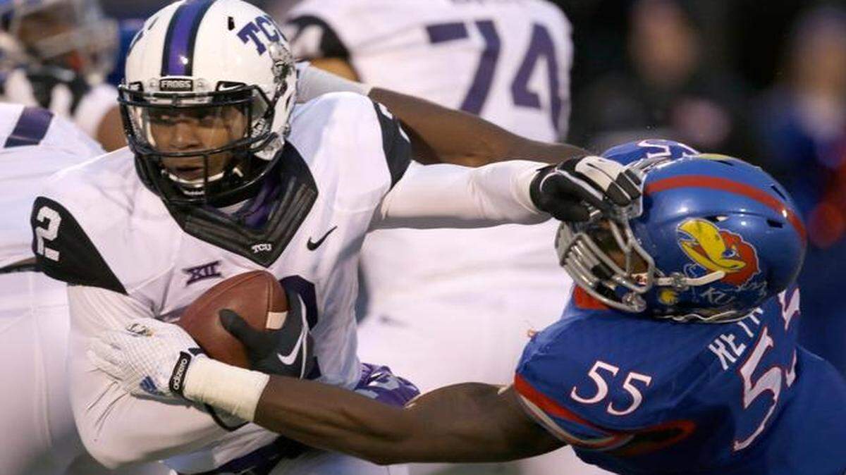 
TCU quarterback Trevone Boykin (2) avoided a tackle by Kansas linebacker Michael Reynolds on Saturday as the Horned Frogs beat the Jayhawks 34-30. The narrow victory caused TCU to slip from fourth to fifth in the College Football Playoff rankings that were released Tuesday night.
